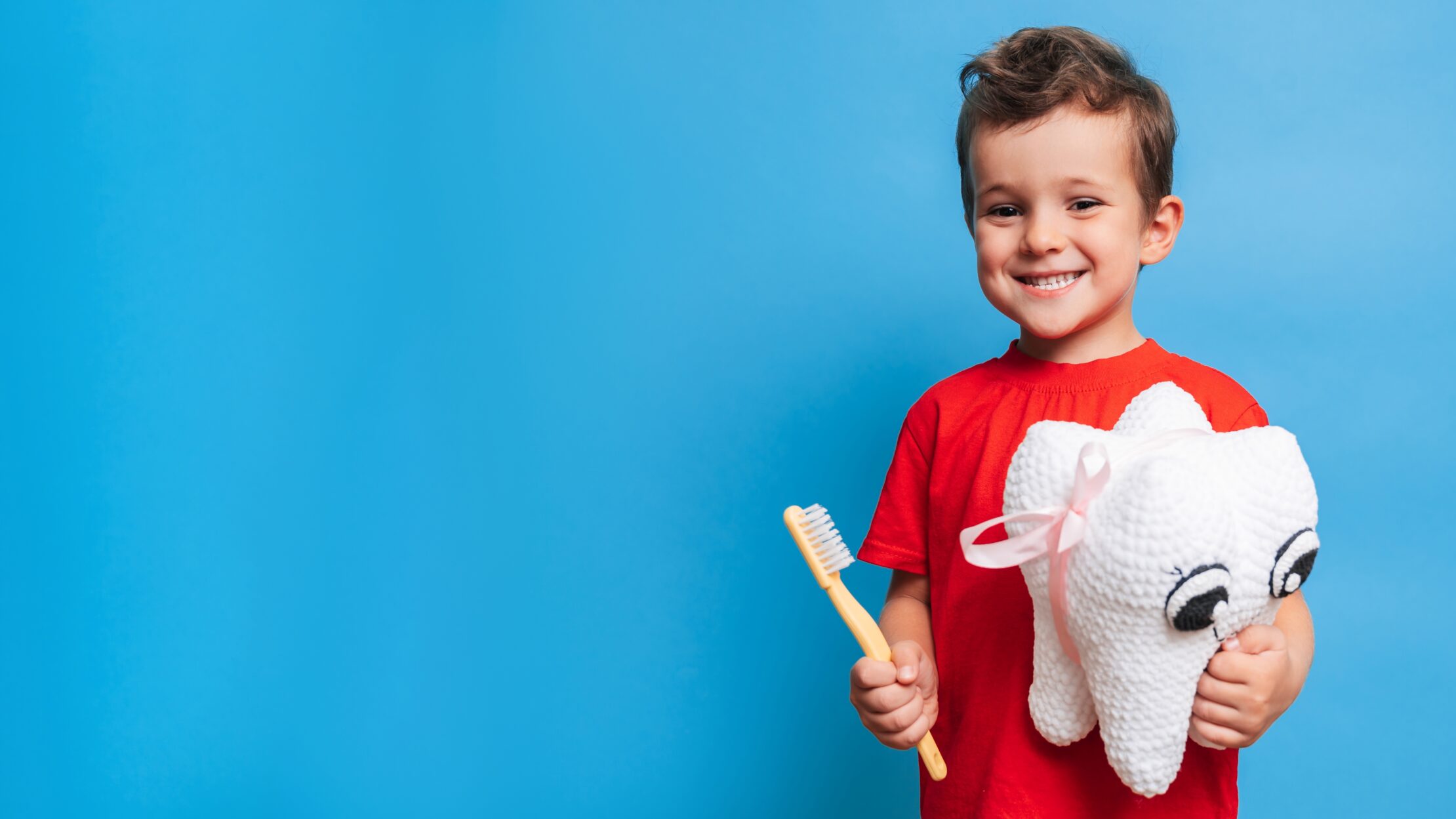 child with toothbrush and plushy